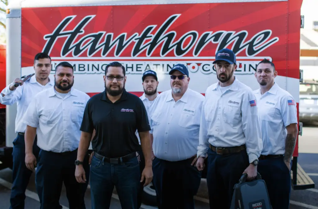 The Hawthorne Plumbing, Heating & Cooling team standing in front of a service truck